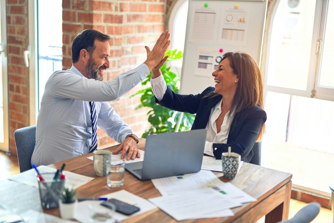 Two people reviewing marketing results together across a desk
